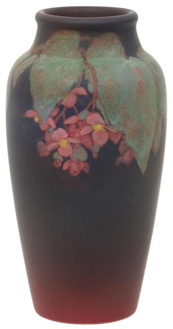 This Rookwood Pottery matte vase ($2,5/3,500) is decorated with large green leaves and pink flowers against a deep purple background, signed by Olga Geneva Reed.